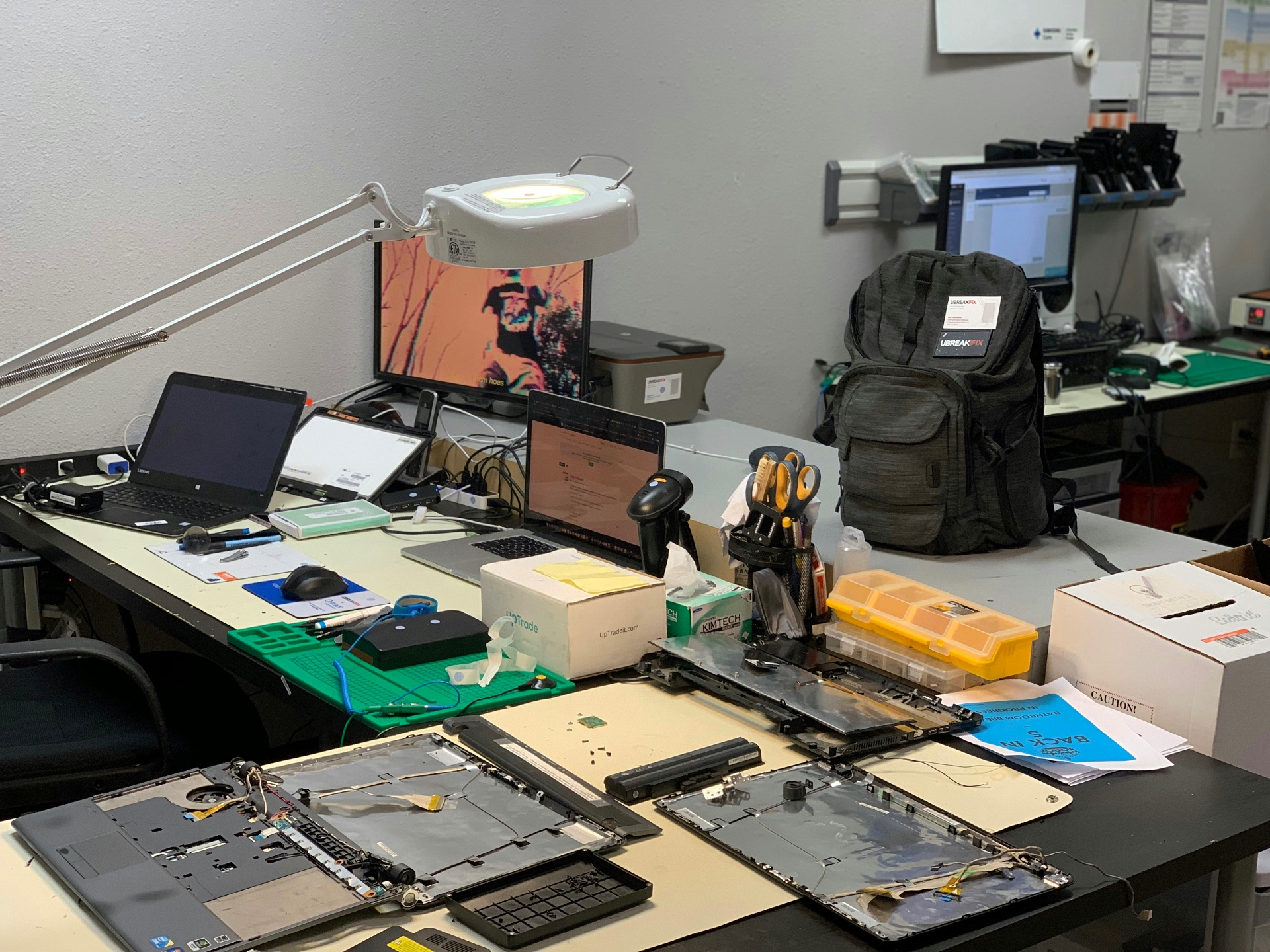 Laptops and parts laid out on The Broken Gadget repair bench